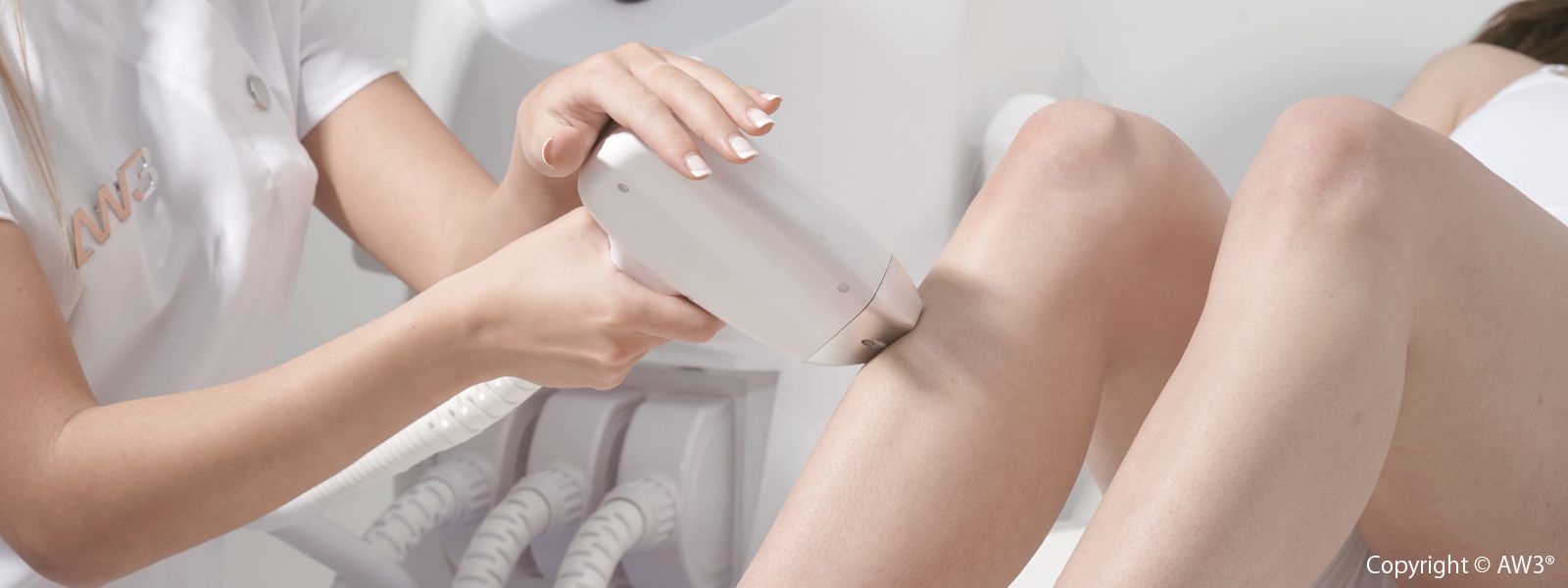 Close-up of a laser hair removal treatment being performed on a client's leg using the AW3® device